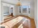 Sunlit dining room boasts hardwood floors, a chandelier, and views of the front entryway at 3905 Colonial Sw Trl, Lilburn, GA 30047