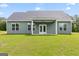 Well maintained backyard features level lawn, green siding and covered patio at 123 Oak Road, Locust Grove, GA 30248