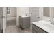 Double vanity bathroom with gray cabinets and tile floor at 13232 Tolstoy Drive, Covington, GA 30014