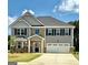 Charming two-story home with a manicured lawn, stone accents, and a two-car garage at 13232 Tolstoy Drive, Covington, GA 30014