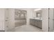 Main bathroom with double vanity, gray cabinets, and view of bedroom at 13232 Tolstoy Drive, Covington, GA 30014