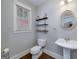 Bathroom featuring a pedestal sink, a toilet, and floating shelves at 37 Highcrest Dr, Acworth, GA 30101