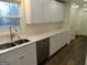 Kitchen features white cabinets, quartz countertops, and stainless steel dishwasher at 553 Highway 279, Fayetteville, GA 30214