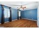 Bedroom with wood floors and plantation shutters with blue painted walls at 1909 Hickory Level Rd, Villa Rica, GA 30180