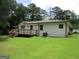 View of the back of the house with a wooden deck and a well-maintained lawn at 215 Elliott Rd, Mcdonough, GA 30252