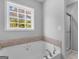 Bathroom with garden tub, large window, and shower at 215 Elliott Rd, Mcdonough, GA 30252