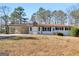 White brick ranch house with light blue door, attached carport, and spacious yard at 215 Elliott Rd, Mcdonough, GA 30252