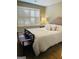 Bedroom with a wooden bench at the foot of the bed, shutters, and modern fixtures at 144 Cottsford Sw Dr # 22, South Fulton, GA 30331