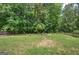 Lush backyard with a fire pit area and a classic wooden fence for privacy at 233 Yorkshire Ln, Villa Rica, GA 30180