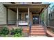 Inviting covered front porch with brick steps, columns, and a cozy porch swing at 233 Yorkshire Ln, Villa Rica, GA 30180