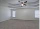 Spacious primary bedroom boasts tray ceilings, neutral carpet, and ample natural light at 233 Yorkshire Ln, Villa Rica, GA 30180