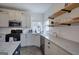 Bright kitchen features open wooden shelves, white cabinets, stainless appliances and white subway tiles at 233 Yorkshire Ln, Villa Rica, GA 30180