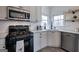 Bright kitchen has stainless appliances, white cabinets, and wooden open shelves at 233 Yorkshire Ln, Villa Rica, GA 30180