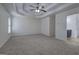 Bright living room features neutral carpet, tray ceiling with fan, and view into a bathroom at 233 Yorkshire Ln, Villa Rica, GA 30180