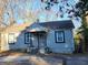 Charming single-story home featuring a covered porch, classic windows, and a compact deck at 4692 College St, Forest Park, GA 30297