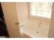 Bathroom features a white soaking tub with window and pink accents at 3013 Pommel Ct, Conyers, GA 30013