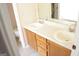 Bathroom with double sinks, wood cabinets and a large mirror at 3013 Pommel Ct, Conyers, GA 30013