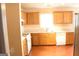Well-lit kitchen featuring wood cabinets, white appliances, and laminate floor at 3013 Pommel Ct, Conyers, GA 30013