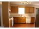 Well-lit kitchen featuring wood cabinets, white appliances, and laminate floor at 3013 Pommel Ct, Conyers, GA 30013