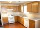 Well-lit kitchen featuring wood cabinets, white appliances, and laminate floor at 3013 Pommel Ct, Conyers, GA 30013