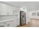 Kitchen featuring stainless steel refrigerator, white cabinets with brass handles, and granite countertops at 3939 Hamilton Mill Rd, Buford, GA 30519