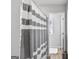 This is a bathroom with a large shower curtain and a white rug. There is a stainless steel trash can at 151 Brasch Park Dr, Grantville, GA 30220