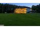 Spacious home with illuminated windows and balconies, set against a backdrop of a vast, grassy lawn at 535 Waters Way, Fayetteville, GA 30215