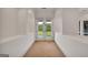 Bright hallway with carpet and double doors leading to balcony with picturesque view of the trees at 535 Waters Way, Fayetteville, GA 30215