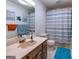 Simple bathroom with striped shower curtain and wood vanity at 130 Seneca Pl, Fayetteville, GA 30215