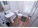 Small bathroom with pedestal sink, toilet and wood-look flooring at 1291 Pleasant Grove Church Rd, Villa Rica, GA 30180