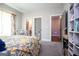 Bright bedroom with an antique-style bed and floral bedding, and a built-in shelving unit at 1291 Pleasant Grove Church Rd, Villa Rica, GA 30180