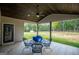 Covered patio with metal table and chairs, overlooking a wooded backyard at 1291 Pleasant Grove Church Rd, Villa Rica, GA 30180