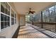 Relaxing back porch with a ceiling fan, wooden floor, and a scenic view of the surrounding nature at 2204 Happy Hollow Se Ct, Conyers, GA 30094