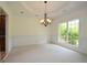 Spacious dining room featuring a decorative chandelier, neutral paint, and wainscoting at 2204 Happy Hollow Se Ct, Conyers, GA 30094