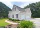 Rear view of the home showing a three-car garage and landscaped grounds at 2204 Happy Hollow Se Ct, Conyers, GA 30094