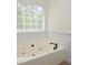 Bathroom with jacuzzi tub under a window at 2204 Happy Hollow Se Ct, Conyers, GA 30094