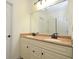 Bathroom featuring a double vanity with tan marble countertop and dark bronze fixtures at 2204 Happy Hollow Se Ct, Conyers, GA 30094