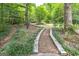 Stone pathway through lush, wooded backyard at 731 Airline Rd, Mcdonough, GA 30252