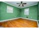 Bedroom with green walls, hardwood floors and ceiling fan at 653 Temple St, Lithia Springs, GA 30122