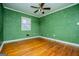 Bedroom with green walls, hardwood floors and ceiling fan at 653 Temple St, Lithia Springs, GA 30122