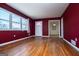 Spacious living room with hardwood floors and burgundy walls at 653 Temple St, Lithia Springs, GA 30122