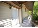Exterior entrance featuring white siding, covered porch, white door, and dark trim at 60 Sweet Bay Ln, Carrollton, GA 30116