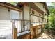 Exterior shot of home with a covered porch, white door, stone foundation, and wooden railings at 60 Sweet Bay Ln, Carrollton, GA 30116