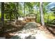 Charming home nestled among trees with a stone facade, covered porch, and driveway at 60 Sweet Bay Ln, Carrollton, GA 30116