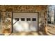 Attached garage door with decorative windows, framed by stone at 60 Sweet Bay Ln, Carrollton, GA 30116
