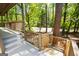 Spacious covered porch featuring white floors, wooden railings, and tree views at 60 Sweet Bay Ln, Carrollton, GA 30116