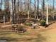 Tranquil backyard featuring a peaceful landscape with a fire pit surrounded by trees and nature at 4780 Rambling Rose Dr, Cumming, GA 30040