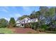 Well-maintained property with mature trees, a lush lawn, and a welcoming front porch at 4780 Rambling Rose Dr, Cumming, GA 30040