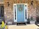 Inviting entrance with a blue door, stone facade, and decorative potted plants at 4780 Rambling Rose Dr, Cumming, GA 30040