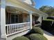 Spacious covered porch with a swing, stone detailing, and manicured shrubs at 4780 Rambling Rose Dr, Cumming, GA 30040